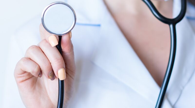 a woman in a white shirt holding a stethoscope