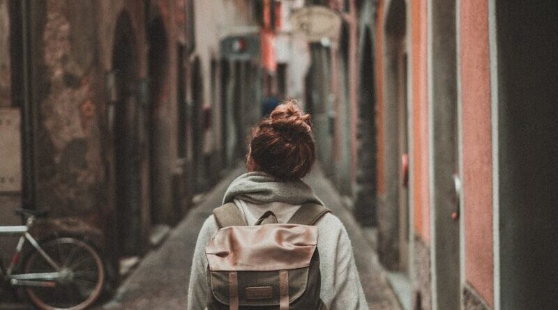 woman walking on street surrounded by buildings