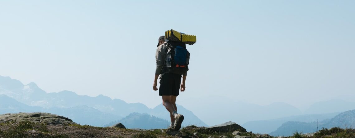 a man with a backpack walking up a hill
