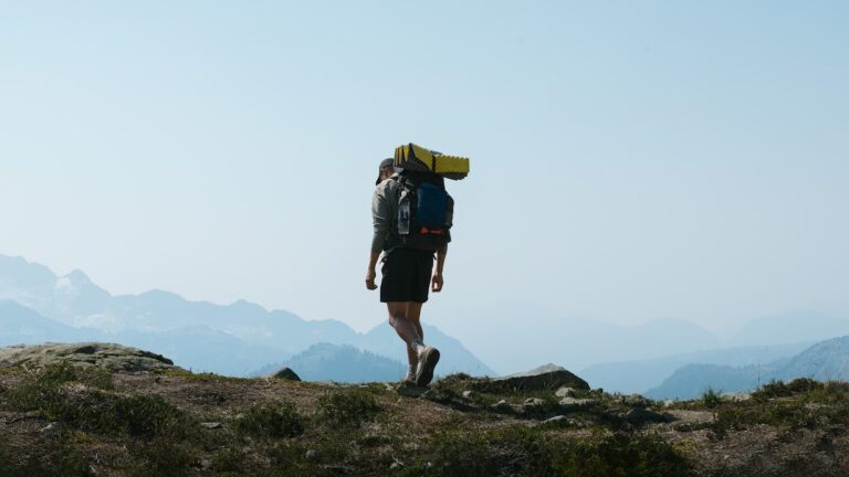 a man with a backpack walking up a hill