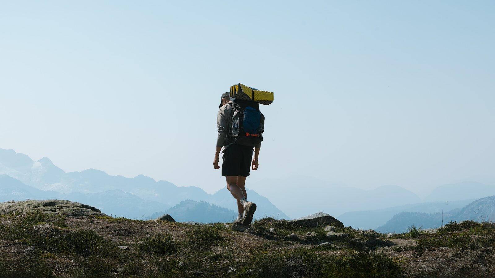 a man with a backpack walking up a hill